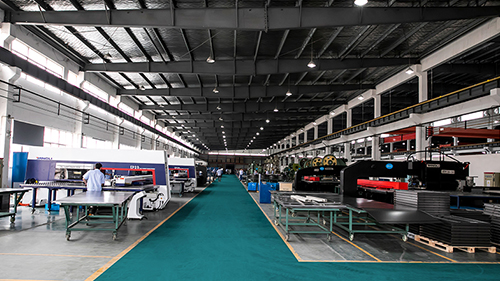Spacious manufacturing workshop with green aisle and heavy machinery for Tablet & laptop charging cart production